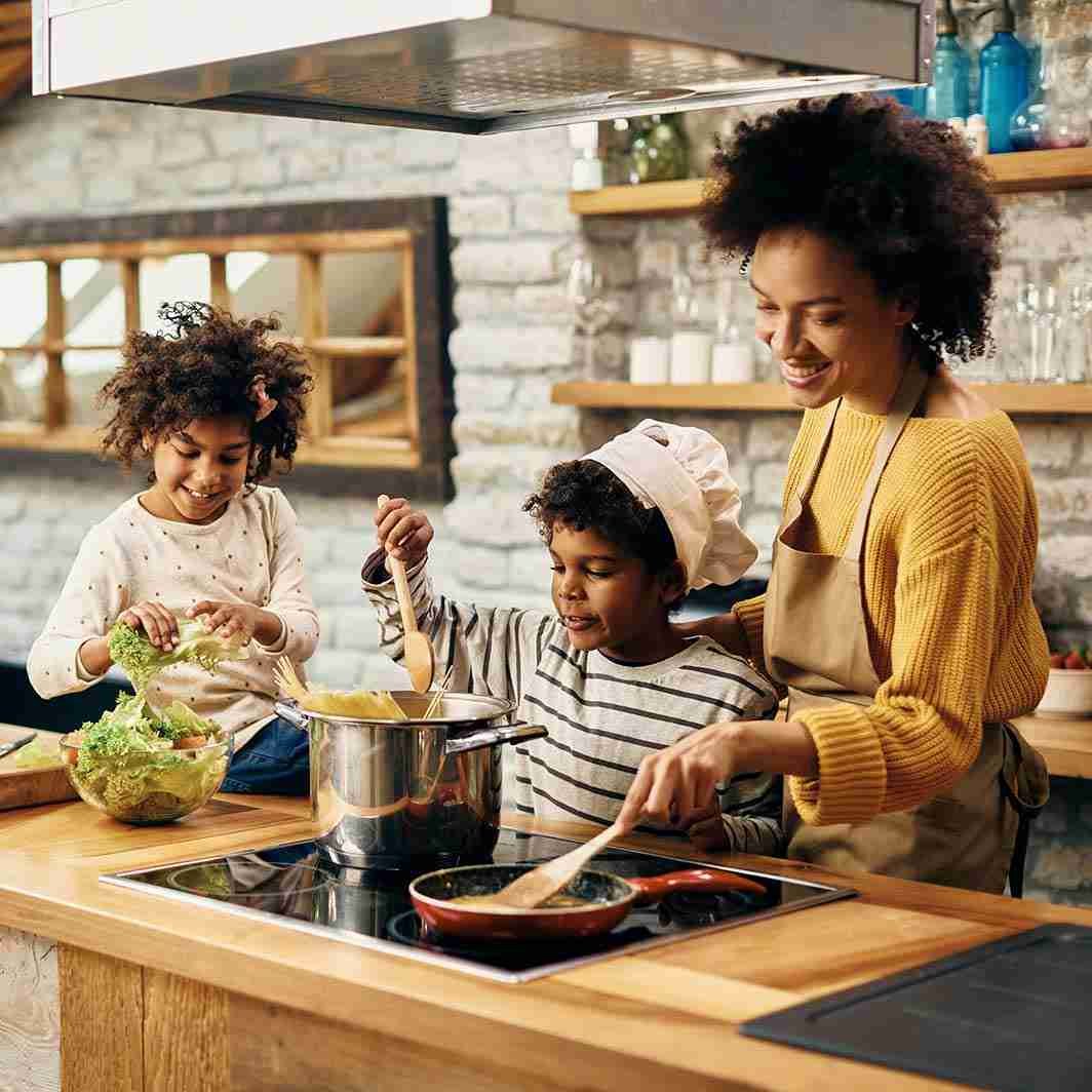 Home_happy-black-mother-her-kids-preparing-food-kitchen