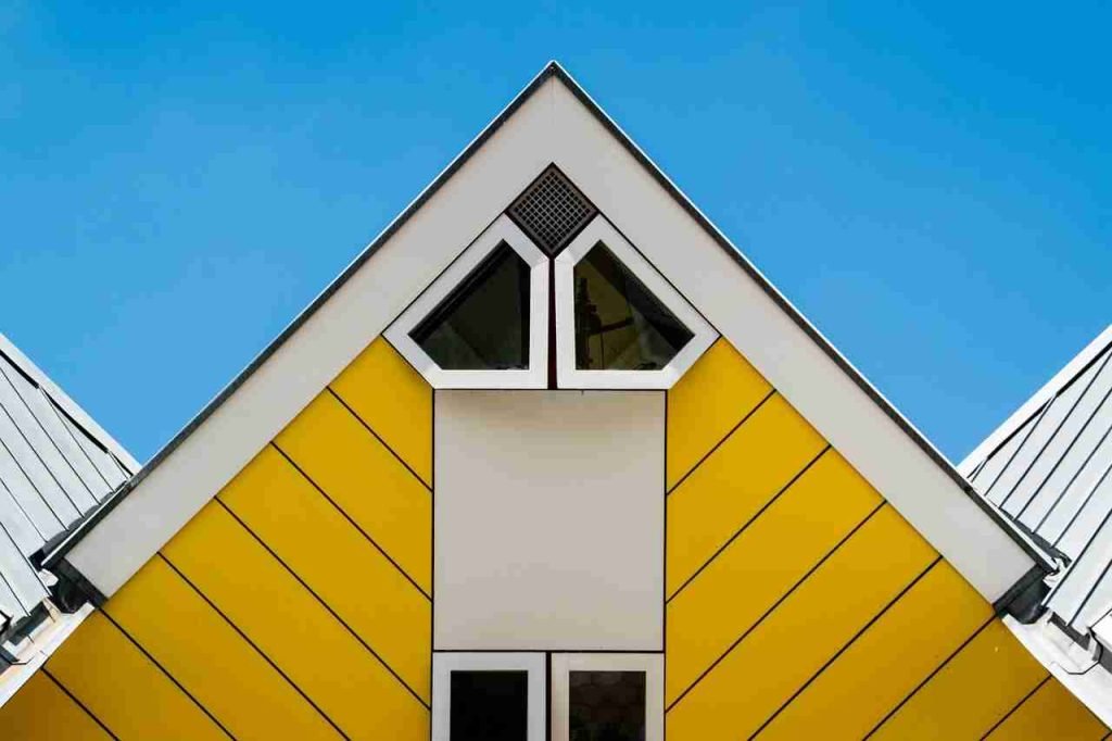 How to Choose the Best Siding for Your Home: Expert Tips and FAQs 3 A striking roof on a cubic house. It is bright yellow with angled siding and geometric windows.